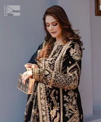 Intricate floral patterns all over! Make a style statement with this elegant embroidered long shirt adorned with golden embroidery decorated with sequins, tilla, dabka, kora, Kundan, heavily embellished bodice, and floral bunches. The round neckline of the following shirt makes this article stunning and charming. The full sleeves of the shirt are also magnified with floral motifs. It is paired up with trousers in the same colour to balance the overall look of this party wear. Complete this outfit with a dupatta framed with four-sided borders and tiny floral motifs all over which is exactly a pure trendy style.