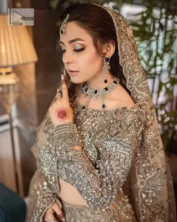 A dreamy statement of brown nikah outfit! This dress proffers a brown hue with its glamorous silver embroidery. The handsome and attractive embellishments include tilla, dabka, kora, Kundan and the real magic of Zardozi. The blouse has a boat-shaped neckline to enhance the features. Further, the floral patterns on full sleeves make this outfit more lovely. It is paired up with meticulously handcrafted lehnga which is bold enough to stand out in the crowd. Complete this article with a scalloped dupatta in the same colour framed with a four-sided border and sequin sprayed all over to make it dreamy.