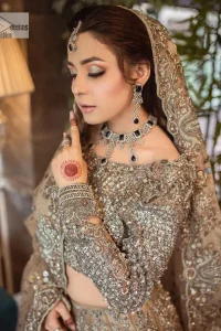 A dreamy statement of brown nikah outfit! This dress proffers a brown hue with its glamorous silver embroidery. The handsome and attractive embellishments include tilla, dabka, kora, Kundan and the real magic of Zardozi. The blouse has a boat-shaped neckline to enhance the features. Further, the floral patterns on full sleeves make this outfit more lovely. It is paired up with meticulously handcrafted lehnga which is bold enough to stand out in the crowd. Complete this article with a scalloped dupatta in the same colour framed with a four-sided border and sequin sprayed all over to make it dreamy.