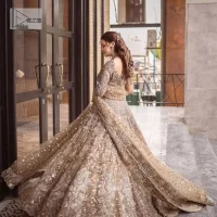 A dreamy statement of brown nikah outfit! This dress proffers a brown hue with its glamorous silver embroidery. The handsome and attractive embellishments include tilla, dabka, kora, Kundan and the real magic of Zardozi. The blouse has a boat-shaped neckline to enhance the features. Further, the floral patterns on full sleeves make this outfit more lovely. It is paired up with meticulously handcrafted lehnga which is bold enough to stand out in the crowd. Complete this article with a scalloped dupatta in the same colour framed with a four-sided border and sequin sprayed all over to make it dreamy.