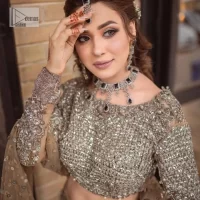 A dreamy statement of brown nikah outfit! This dress proffers a brown hue with its glamorous silver embroidery. The handsome and attractive embellishments include tilla, dabka, kora, Kundan and the real magic of Zardozi. The blouse has a boat-shaped neckline to enhance the features. Further, the floral patterns on full sleeves make this outfit more lovely. It is paired up with meticulously handcrafted lehnga which is bold enough to stand out in the crowd. Complete this article with a scalloped dupatta in the same colour framed with a four-sided border and sequin sprayed all over to make it dreamy.