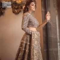 A dreamy statement of brown nikah outfit! This dress proffers a brown hue with its glamorous silver embroidery. The handsome and attractive embellishments include tilla, dabka, kora, Kundan and the real magic of Zardozi. The blouse has a boat-shaped neckline to enhance the features. Further, the floral patterns on full sleeves make this outfit more lovely. It is paired up with meticulously handcrafted lehnga which is bold enough to stand out in the crowd. Complete this article with a scalloped dupatta in the same colour framed with a four-sided border and sequin sprayed all over to make it dreamy.