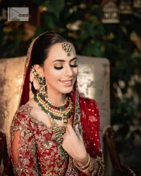 Classic deep red canvas with a bold twist of the pattern!  Bridal choli in the deep red shade is a beautiful attire to wear on the big day to have an elegant and classy look. This beautiful choli is heavily embellished with crystals, pearls, dabka,tilla, kora, Kundan, stones, and Zardozi giving a magnificent touch to the lehenga choli. The round neckline of the attractive blouse makes an outfit look more sophisticated. Further, the beautiful floral patterns on three-quarter sleeves make this outfit a must-have for your day. It is paired with a heavily embellished lehenga and is a stylish choice for the gorgeous Bride. Complete this romantic article with a dupatta framed with four-sided embellished borders and sequins sprayed all over.