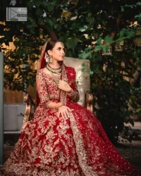 Classic deep red canvas with a bold twist of the pattern!  Bridal choli in the deep red shade is a beautiful attire to wear on the big day to have an elegant and classy look. This beautiful choli is heavily embellished with crystals, pearls, dabka,tilla, kora, Kundan, stones, and Zardozi giving a magnificent touch to the lehenga choli. The round neckline of the attractive blouse makes an outfit look more sophisticated. Further, the beautiful floral patterns on three-quarter sleeves make this outfit a must-have for your day. It is paired with a heavily embellished lehenga and is a stylish choice for the gorgeous Bride. Complete this romantic article with a dupatta framed with four-sided embellished borders and sequins sprayed all over.
