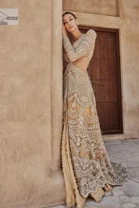 Bold, edgy, and wrapped in glamour. A sumptuous palette of gold with silver delicate embroidery, signature handcrafted embellishment includes tilla, dabka, kora, Kundan, Zardozi and crystals. Take your look to the next level with this golden front open gown which has V shape neckline and full sleeves. The floral patterns on the following gown just steal everyone's heart on your big day. It is paired up with a lehenga to enhance the beauty of this nikah outfit. Complete this article with a dupatta framed with four-sided embellished borders and sequins sprayed all over to wrap you in a bold outfit.