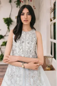 Shine and sparkle in this ice-blue nikah outfit! A mesmerizing long shirt stuns in a beautifully handcrafted silver embroidery enshrined with tilla,dabka, kora, Kundan, Zardozi, stones and the real magic of crystals. The jewel neckline has detailed intricate floral patterns. The sleeveless style of this ice blue front open shirt is the true essence of DeemasFashion. It is organized with a plain lehenga in the same colour to complete your stylish appearance.