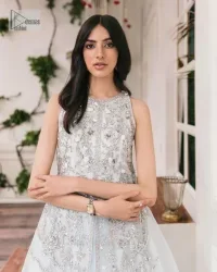 Shine and sparkle in this ice-blue nikah outfit! A mesmerizing long shirt stuns in a beautifully handcrafted silver embroidery enshrined with tilla,dabka, kora, Kundan, Zardozi, stones and the real magic of crystals. The jewel neckline has detailed intricate floral patterns. The sleeveless style of this ice blue front open shirt is the true essence of DeemasFashion. It is organized with a plain lehenga in the same colour to complete your stylish appearance.
