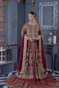Bold and classy colour for the reception outfit! The maroon gown is breathtakingly adorned with hand-crafted embellishments and intricate designs. It is enhanced with tilla, dabka, Koran, Kundan and details of Zardozi. The round neckline is emblazoned with golden embroidery to make this masterpiece romantic. The full sleeves of the following scalloped gown are adorned with fine details. It is paired with flared lehenga which is also heavily embellished giving a royal look to the gorgeous bride. Finish this maroon outfit with a dupatta which is ornamented with four-sided borders and sequins sprayed all over to create an exquisite dress.