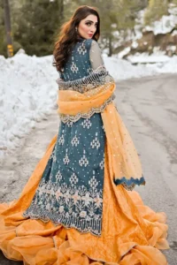 The long shirt is coordinated with an orange lehenga and dupatta. Its comfortable and free-flowing design ensures you move with ease as you revel in the festivities. The bright and lively colour palette adds a playful charm to your attire.