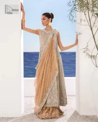 The silver and golden embroidery is the highlight of the party outfit! Keep it dreamy and classic with DeemasFashion. The handsome light orange long shirt is gracefully embellished with silver and gold embroidery that gives you a head-turning appearance on the wedding day. The shirt is enhanced with tilla, dabka, kora, Kundan, and crystals. The round neckline of the shirt makes this glamorous attire an epitome of royalty and grace. It is paired up with crushed sharara to make this masterpiece unique.  A light orange dupatta has a sequin-sprayed surface with branching tiny floral motifs all over. The beautifully embellished border envelopes the dupatta.