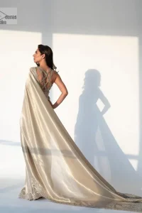 It's an aesthetic kinda mood. A silver blouse hand embellished with dabka, naqshi, cut dana, Resham, tilla, kora, sequin and Kundan. A heavily embellished blouse featuring floral patterns encompassing a breathtaking keyhole and vertical embellishments along the strips of the back flare. The V shape neckline of the blouse looks divine when comes with a sleeveless style. It is paired with a scalloped saree with an embellished border and the pallu is decorated with silver embroidery to make this Nikah outfit lovely and charming. 