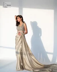 It's an aesthetic kinda mood. A silver blouse hand embellished with dabka, naqshi, cut dana, Resham, tilla, kora, sequin and Kundan. A heavily embellished blouse featuring floral patterns encompassing a breathtaking keyhole and vertical embellishments along the strips of the back flare. The V shape neckline of the blouse looks divine when comes with a sleeveless style. It is paired with a scalloped saree with an embellished border and the pallu is decorated with silver embroidery to make this Nikah outfit lovely and charming. 