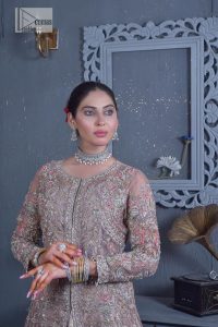 Get cosy in a tea rose nikah outfit. DeemasFashion presents this tea rose front open gown which is heavily embroidered in multiple colours and then further enhanced with the heavy embellishment of tilla, dabka, kora, Kundan and Zardozi making it a perfect fit for brides. The stones touch-up on the round neckline increases the look of the beautiful gown. Furthermore, the full sleeves style of the following gown makes this masterpiece stunning and stylish. It is paired up with flared lehenga in the same colour to balance the overall look of this magnificent attire. Finish this with a dupatta having four-sided borders that gives an everlasting impact on the bride.