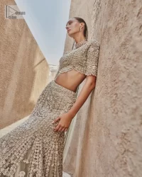 This fusion of floral embroidery is total fashion goodness for a walima outfit! A stunning teal grey organza choli embellished with intricate detailing finished with a scalloped border. The beautiful blouse is decorated with silver embellishment which is further prominent with tilla,daka, kora, Kundan and the real magic of Zardozi.  It is paired with a heavily embellished back-train lehenga with botanical motifs and geometric patterns. Its dupatta is made from a net. The dupatta is a wide embellished border that added divine charm to the entire ensemble.