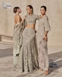 This fusion of floral embroidery is total fashion goodness for a walima outfit! A stunning teal grey organza choli embellished with intricate detailing finished with a scalloped border. The beautiful blouse is decorated with silver embellishment which is further prominent with tilla,daka, kora, Kundan and the real magic of Zardozi.  It is paired with a heavily embellished back-train lehenga with botanical motifs and geometric patterns. Its dupatta is made from a net. The dupatta is a wide embellished border that added divine charm to the entire ensemble.