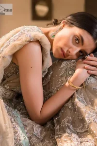 Your wedding vibe. Your wedding mood. Your wedding scent. The light fawn back train heavy maxi and dupatta are hand embellished with straight tilla, dabka, Kundan, Zardozi and kora with running hangings of pearls, crystals, and flat sequins. The sleeveless style of the following back train maxi gives a romantic touch to the whole walima wear. Further, the jewel neckline makes this symbol of beauty. It is paired up with a dupatta framed with a four-sided embellished border with our statement floral pattern and sprayed sequins to make you feel fresh and bold.