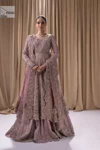 Stand out and stay pink with this nikah wear! The delightful article in pink colour is a traditional masterpiece that will give the gorgeous bride a head-turning look at the wedding. The frock has a sweetheart neckline to make this outfit lovely. It is adorned with silver and golden embroidery which is magnified with tilla, dabka, Koran, Kundan and the details of Zardozi. Further, the combination of tiny and large floral motifs on full sleeves provides a perfect finishing look to this masterpiece. It is paired up with a lehenga in the same colour making it an epitome of beauty and grace. Finish this with a dupatta framed with four-sided embellished scalloped borders and tiny floral motifs all over.