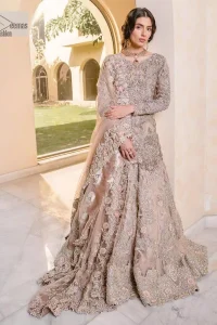 Let your nikah outfit do the talking.  An elegant rhyme to tradition, this short shirt and lehenga create aesthetical magic with its eye-catching hues of rose pink. The beautiful article shines with silver embellishments and an amalgamation of floral patterns which is enhanced with tilla, dabka, kora, Kundan and the detailing of Zardozi.  The full sleeves are heavily embroidered with floral patterns. Further, the V shape neckline makes this epitome of beauty. The lehenga is also intensified with beautiful embroidery. The perfect opulent short-shirt lehenga outfit is paired with an organza dupatta which is adorned with a four-sided embellished border and sequins sprayed all over