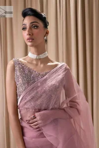Turn heads in our stunning bridesmaid saree! The beautiful tea pink blouse is adorned with silver and golden embroidery which is intensified with tilla, dabka, kora, Kundan and the details of Zardozi. The V shape neckline provides a perfect finishing look to this masterpiece. In addition to this, the sleeveless style of the following blouse makes this outfit unique and romantic. It is paired up with a frilled saree which is plain just to enhance the beauty of this lovely outfit. 