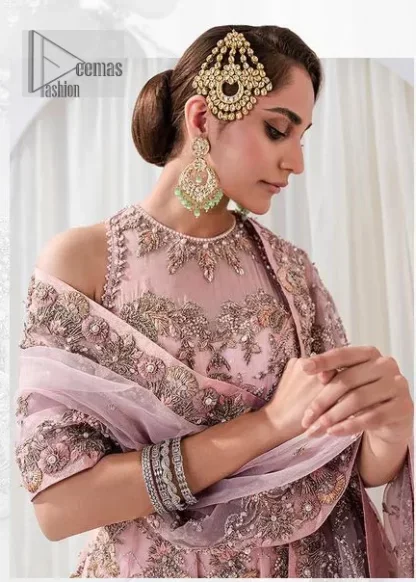 Matching embellishments are here to stay. The attractive tea pink nikah article is a stunning attire adorned with tilla, dabka, kora, Kundan, Zardozi and Gota.  Hand-crafted embellishments of golden and silver embroidery and floral patterns give a perfect finishing look to the maxi. The following scalloped maxi has a jewel neckline to make this unique and charming. In addition to this, the sleeveless style of the maxi is a breathtaking masterpiece that will give the gorgeous bride a breathtaking traditional look at the wedding. It is paired up with a plain lehenga to balance the astonishing look. Finish this with a dupatta that has four-sided embellished borders and tiny floral motifs all over to make your day glow and flowery.