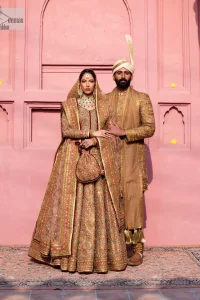 Create a look that’s for you with just one twist of this reception wear. A soft brown short shirt heavily embellished with tilla, dabka, Kora, Zardozi and Kundan. This beautiful dress has Mughal-inspired motifs, geometrical patterns, floral motifs and appliquéd silks. The round neckline makes this masterpiece unique and lovely. In addition to this, the full sleeves also admire its beauty. A lehenga supports it with an embellished border. The organza dupatta has a sequin-sprayed surface with branching floral motifs and it is enveloped with four-sided beautiful borders.