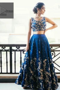  Highlight your entire look and add a touch of sophistication with delicate details. This Party outfit from DeemasFashion is a stunning masterpiece that captures everyone's heart with its charm and elegance upon very first glance. The Royal blue blouse is adorned with Golden embroidery, making it a head-turning masterpiece. Moreover, the square neckline is fully embellished with tilla, dabka, kora, Kundan, and pearls, lending it a magical appearance. The sleeveless style adds a touch of allure to this already captivating outfit. It is paired with an embroidered lehenga to enhance your day's look, and the article is completed with a dupatta featuring tiny floral motifs and sequins sprayed all over.