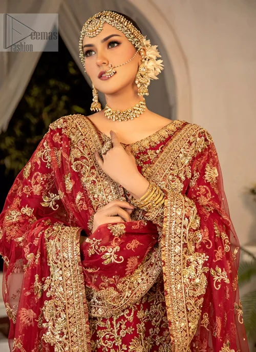 The rich red hue is adorned with intricate golden embroidery that sparkles with every movement.