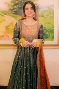 Model wearing bottle green maxi, indigo lehenga, and rust dupatta at a mehndi venue.