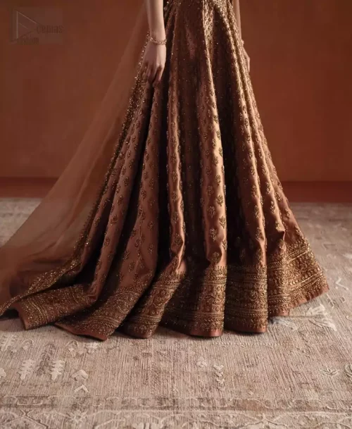 Train Detail: The dramatic back train of the bronze lehenga, intricately worked with tiny motifs sprinkled across the pure silk.